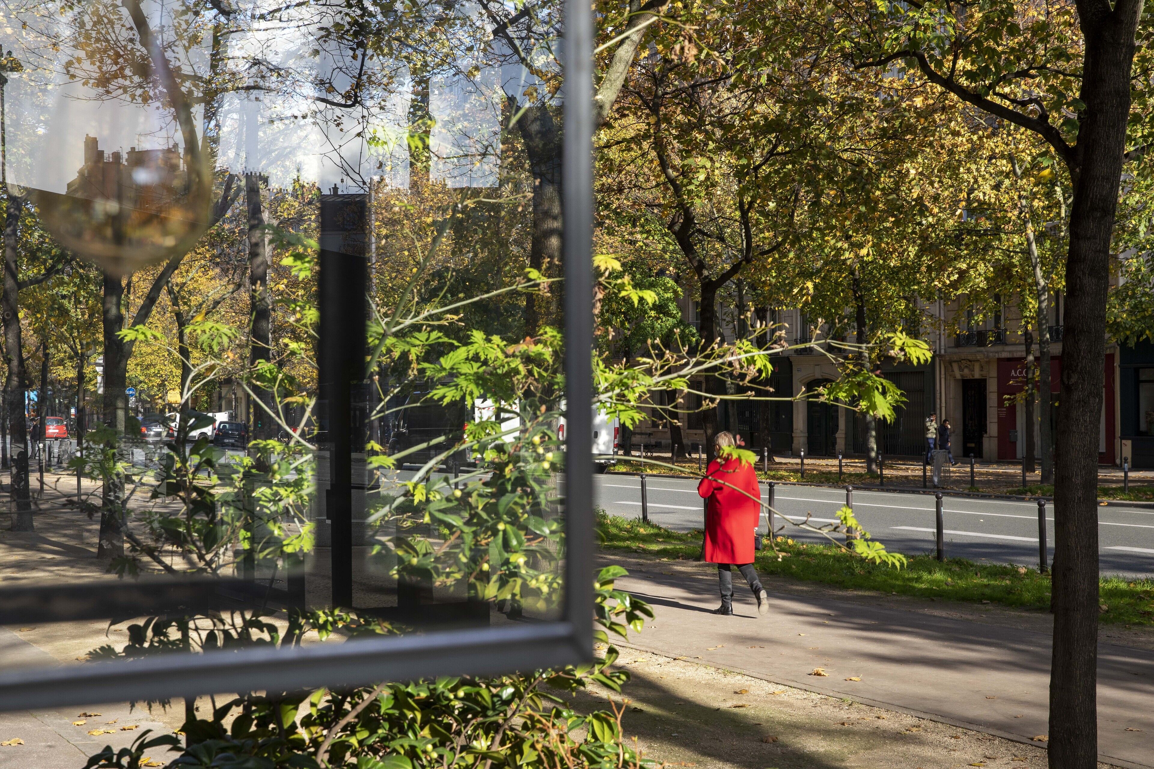 A pedestrian pathway with trees and a building in the background.