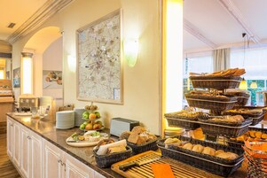 Montaje de bufé con diferentes opciones de comida y un mapa en la pared.