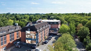 Ein Hotel mit mehreren Parkplätzen, einem gut sichtbaren Eingang und einem Gebäude, das mit einem Schild als Hotel gekennzeichnet ist.