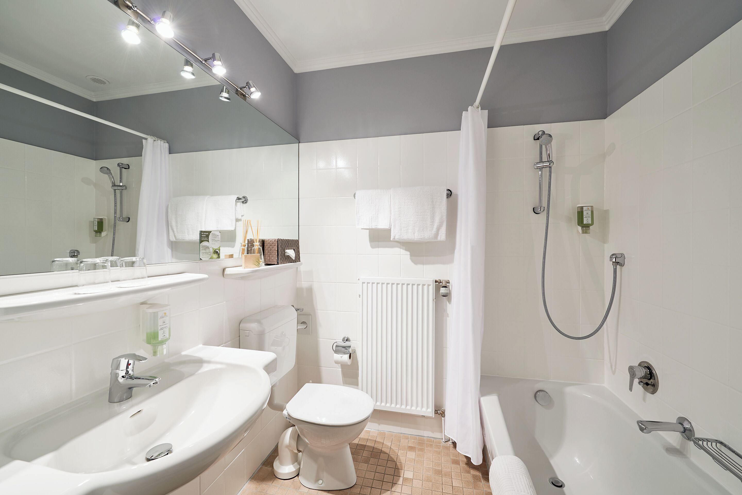 A modern bathroom with a sink, toilet, and bathtub.