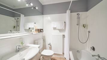 A modern bathroom with a sink, toilet, and bathtub.