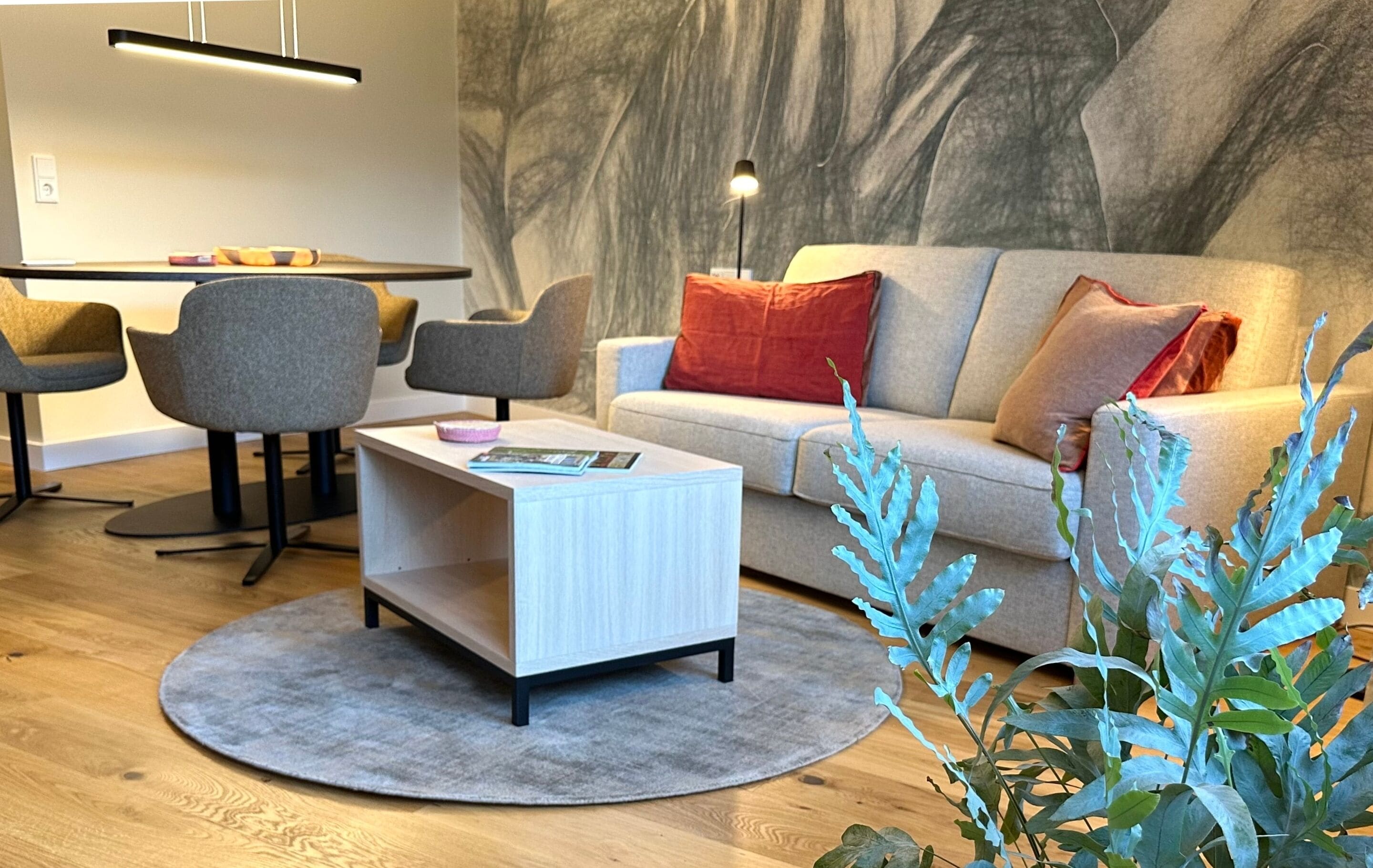 Una sala de estar moderna con sofá, sillas, una mesa de centro y un comedor con sillas y una mesa.
