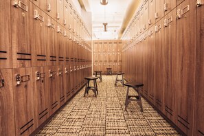 A locker room with wooden lockers, a patterned carpet, and two stools. - Los Angeles Athletic Club (Los Angeles)