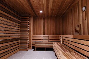 Una sauna con bancos de madera y paredes de listones.