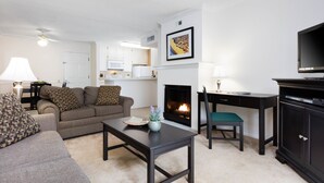Een woonkamer met een open haard, een televisie en een eethoek.