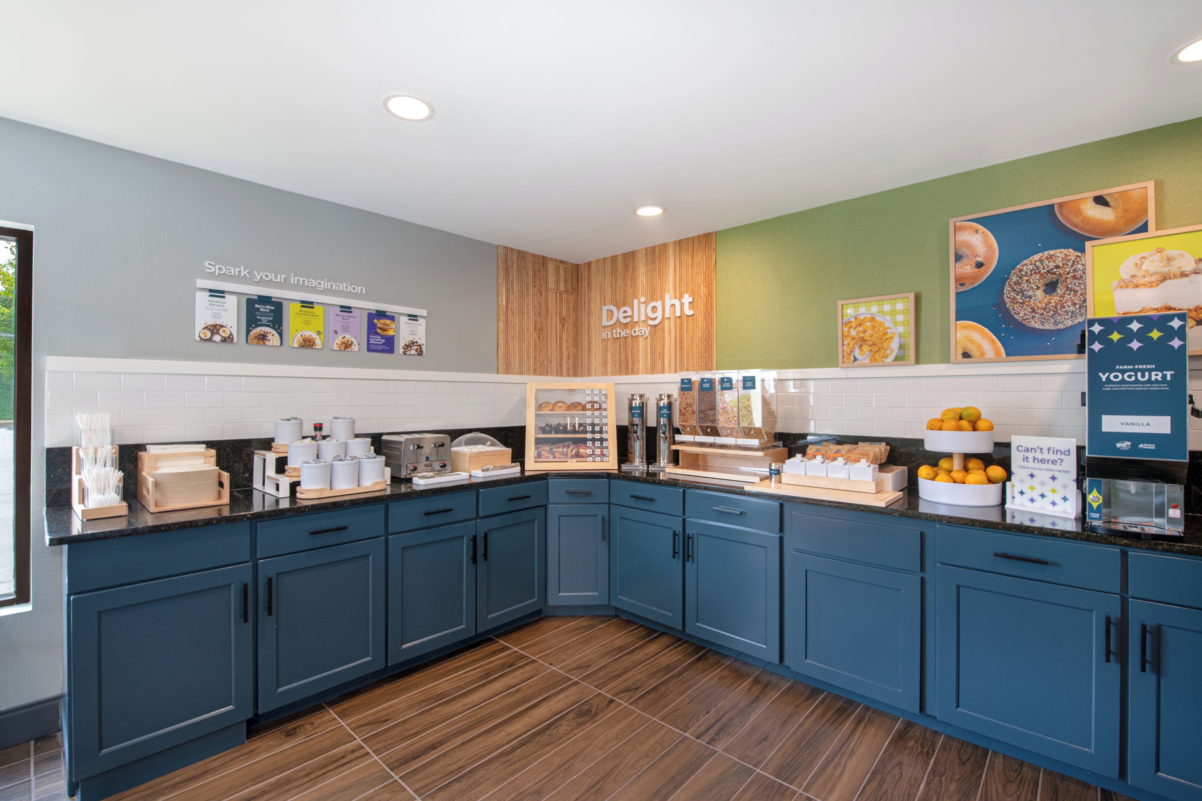 Cocina moderna con armarios azules, un muro decorativo de madera y diversos alimentos exhibidos.