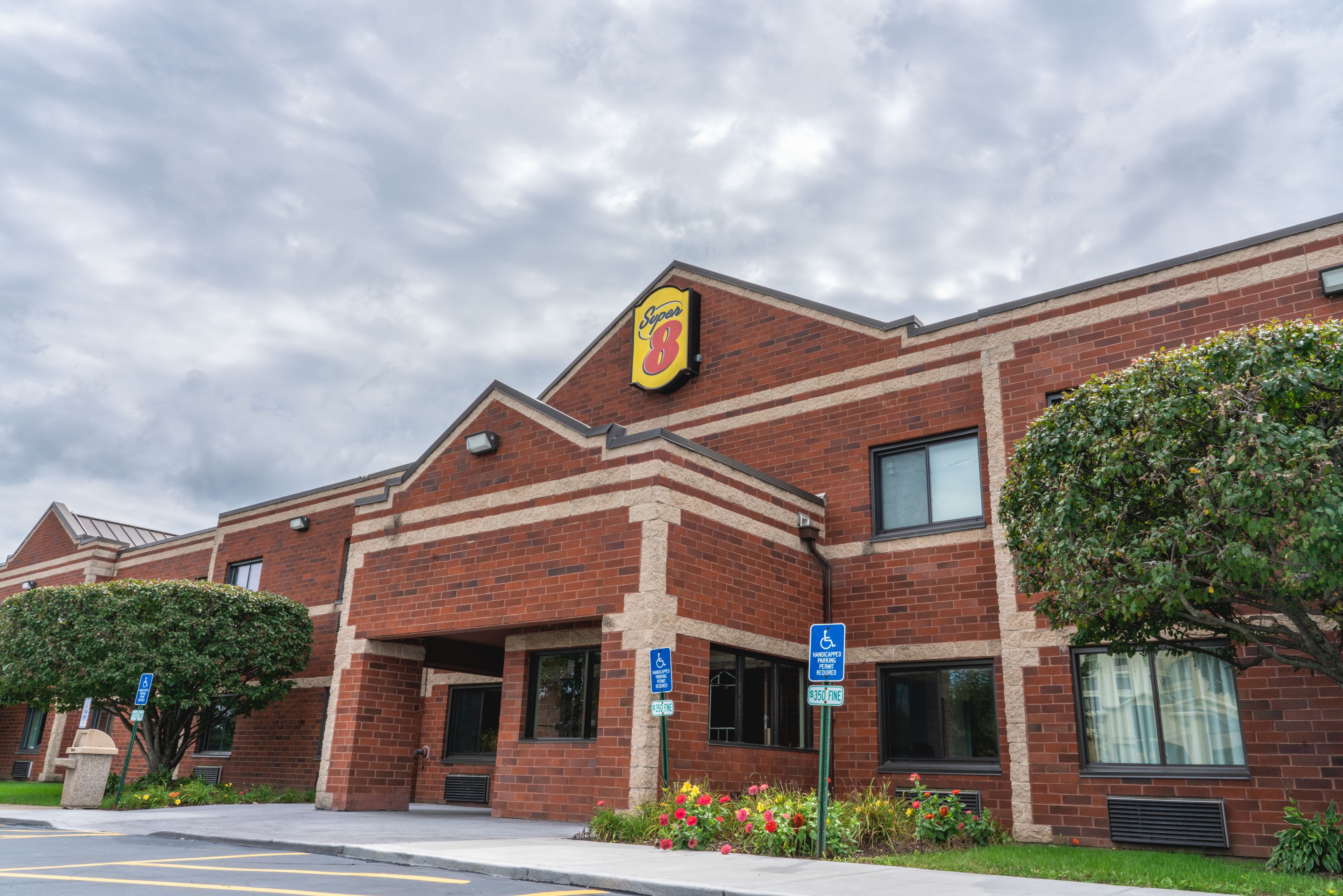 A brick building with a yellow sign reading "Synergy 8" and a wheelchair accessibility sign.