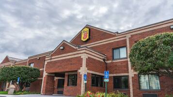 A brick building with a yellow sign reading "Synergy 8" and a wheelchair accessibility sign.