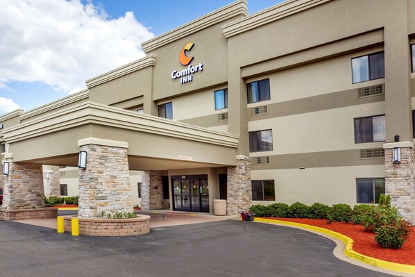 Stylish hotel building with a flat roof and symmetrical facade, featuring a prominent entrance and beautifully landscaped surroundings.