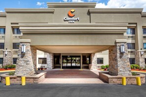 Welcome to Comfort Inn, featuring a modern entrance with a glass door and stone pillars.