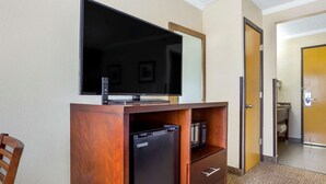 A hotel room with a flat-screen TV, a mini-fridge, a microwave, and a wooden desk. - Comfort Inn Hoffman Estates - Schaumburg (Hoffman Estates)