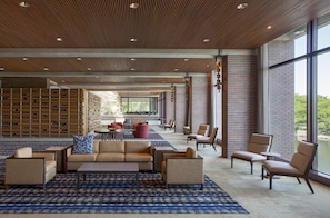 Un'ampia hall con tappeto decorato, divani, poltrone e un tavolino.