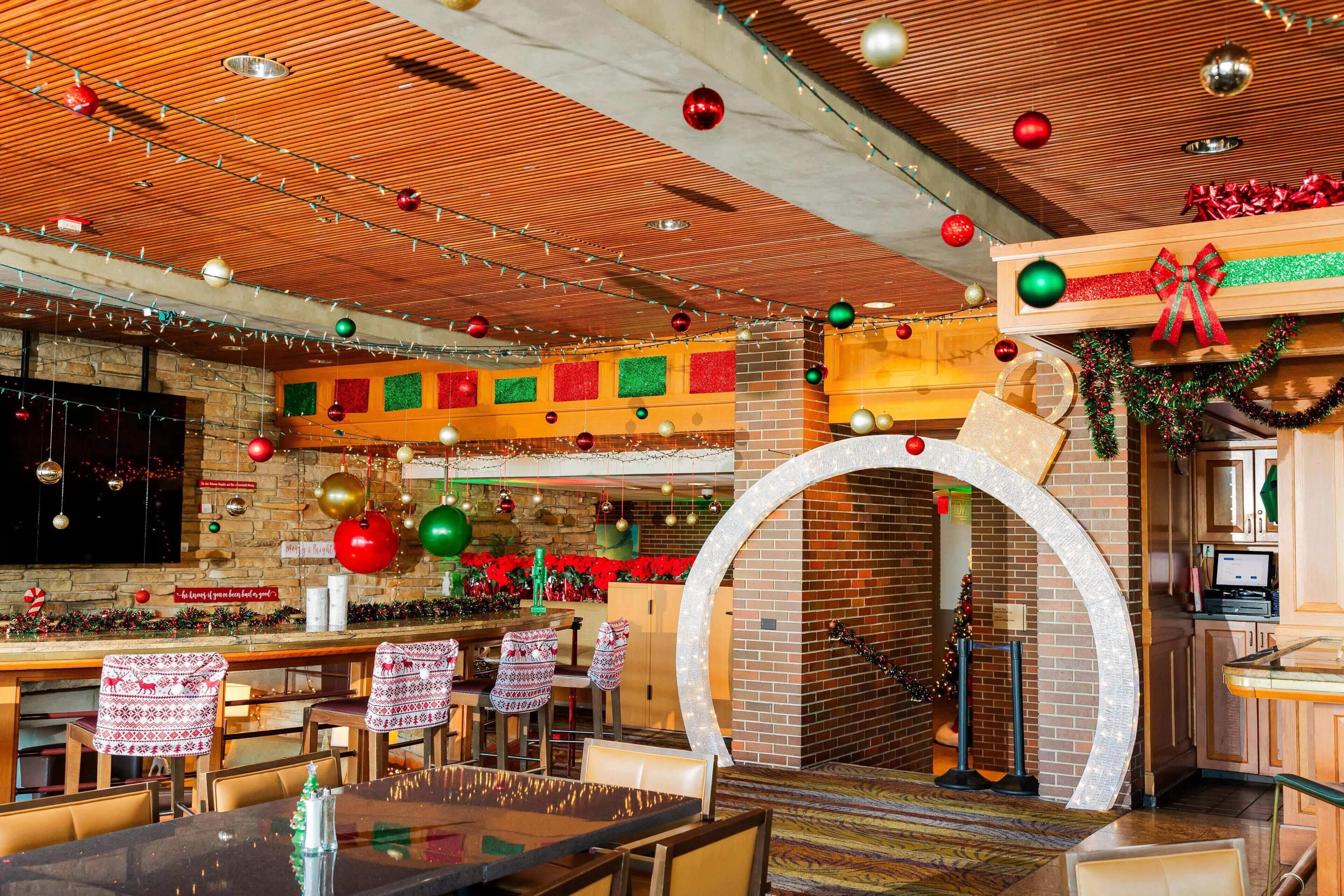A restaurant with brick walls, wooden ceiling, and festive decorations.