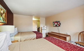 Habitación de hotel con dos camas, un aparador, un microondas y un televisor.