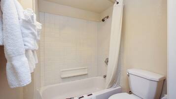 A bathroom with a bathtub, a toilet, and a shower curtain.