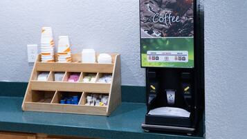 A coffee machine and a dispenser with cups and napkins.