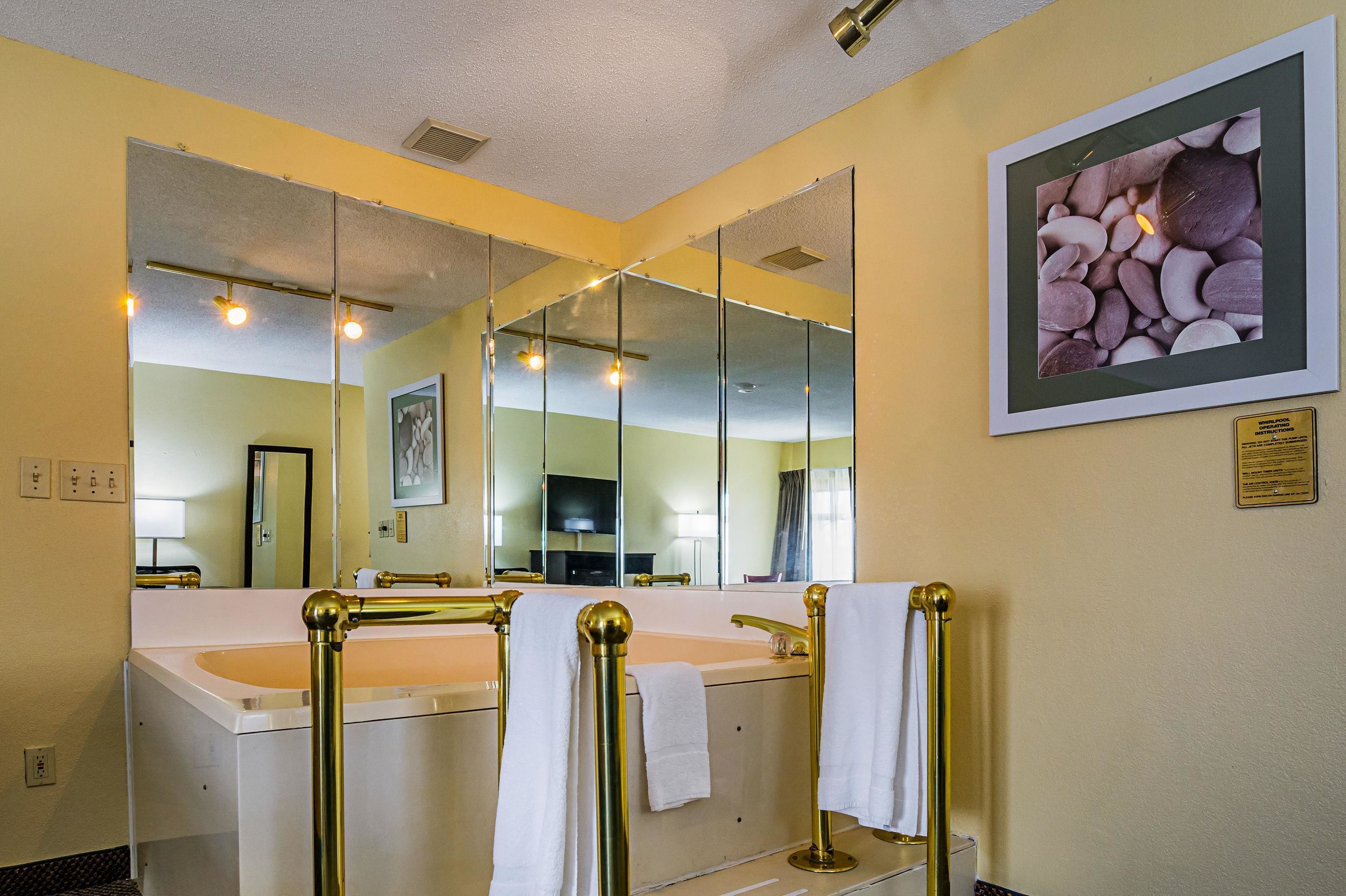 A bathroom with two sinks, gold fixtures, and a large mirror.