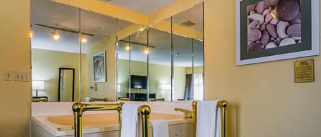 A bathroom with two sinks, gold fixtures, and a large mirror.