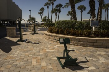 A reception area with a stone wall, wooden reception desk, and artwork on the walls. at Sailport Waterfront Suites