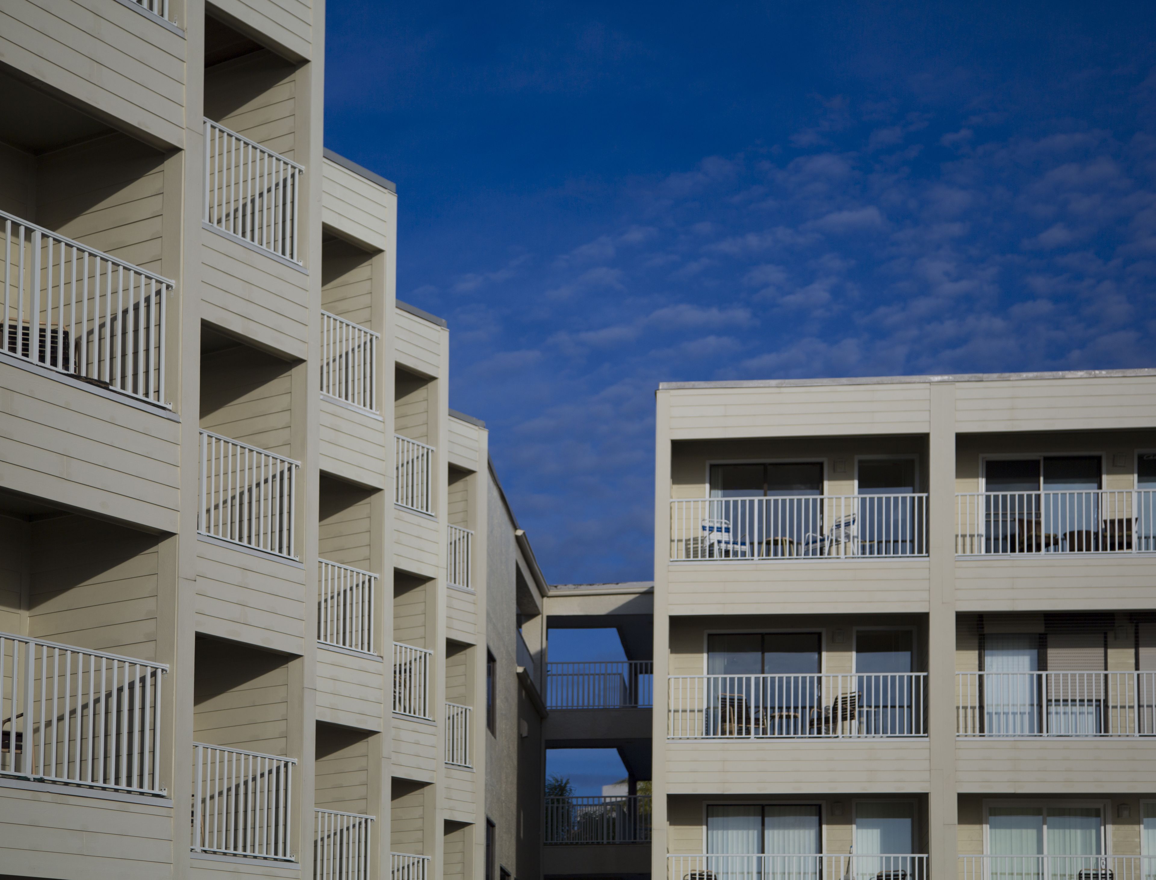 Un edificio de varios pisos con balcones y ventanas amplias.
