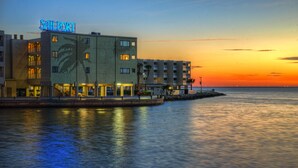 Un hotel frente al agua con un cartel que dice "SAILPORT" y varios balcones.