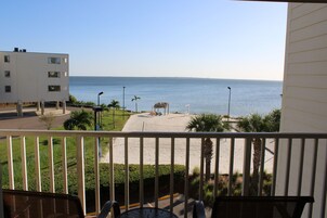 A balcony with a view of a beach and ocean.