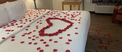 Una habitación de hotel con una cama bien hecha, una lámpara de noche, un teléfono y una mesita.