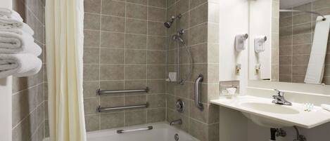 A modern bathroom with a bathtub, shower, and sink.