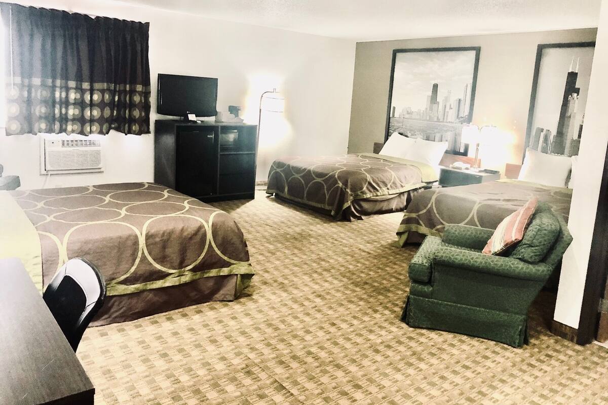 Habitació d'hotel amb dos llits, un escriptori, una cadira i una televisió.