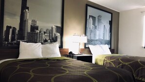Una habitación de hotel con dos camas, un espejo grande con un cuadro de un paisaje urbano y una mesita de noche con una lámpara.