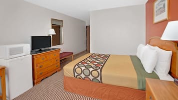 A hotel room with a bed, a television, a dresser, and a microwave.