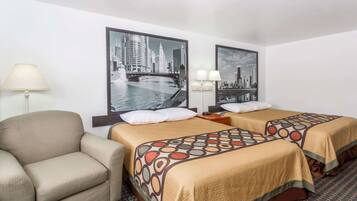 A hotel room with two beds, a sofa, and a lamp.