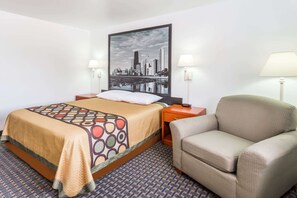 Une chambre d’hôtel avec un lit, une chaise, une table de chevet, une lampe et un tableau représentant un paysage urbain accroché au mur.
