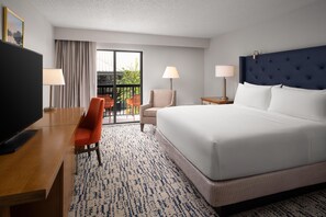 A hotel room with a bed, a desk, a chair, two lamps, and a television. - DoubleTree by Hilton Gainesville (Gainesville)