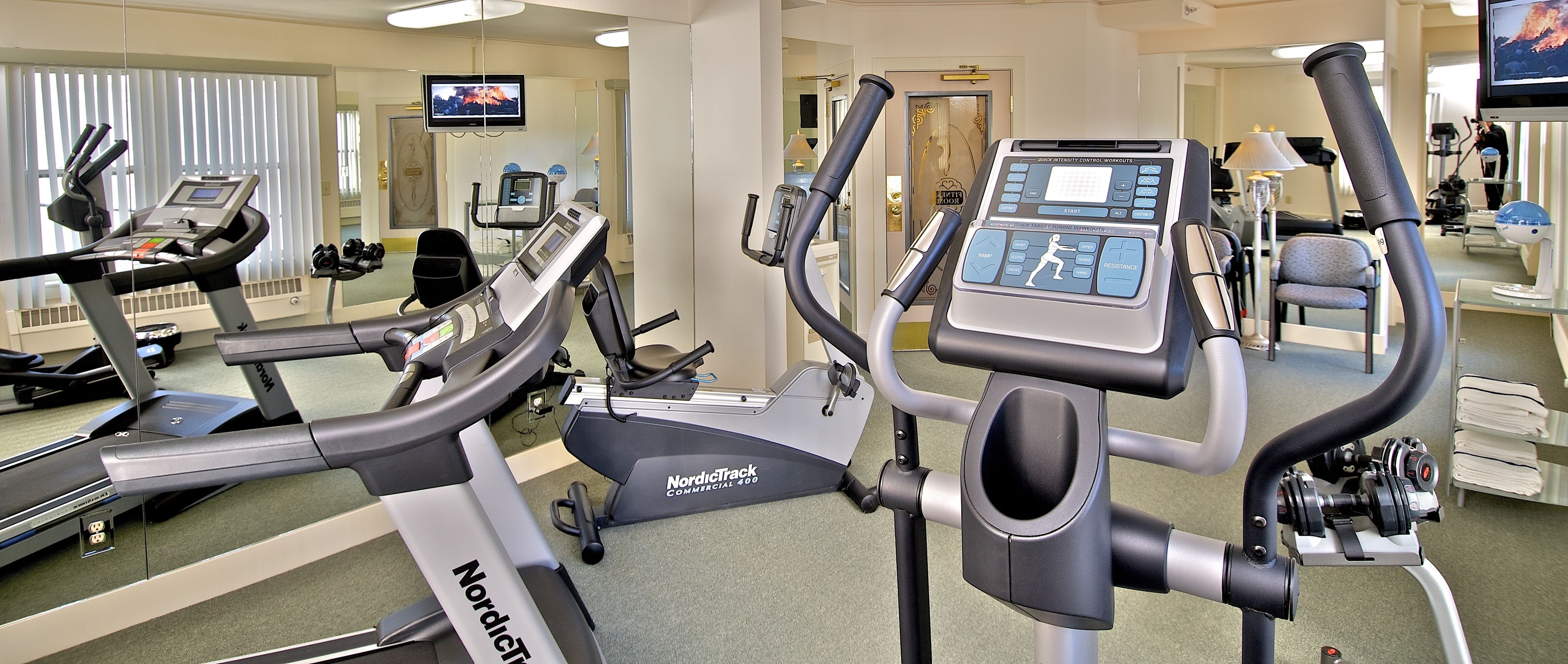 A gym with treadmills, an elliptical, and a NordicTrack Commercial 400.