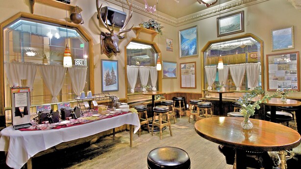 Un restaurant avec des tables et des chaises en bois, et une nappe blanche.