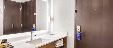 Une salle de bain moderne avec un grand miroir, deux vasques et des meubles en bois.