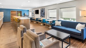 A modern hotel lobby with a bar, seating area, and large windows.
