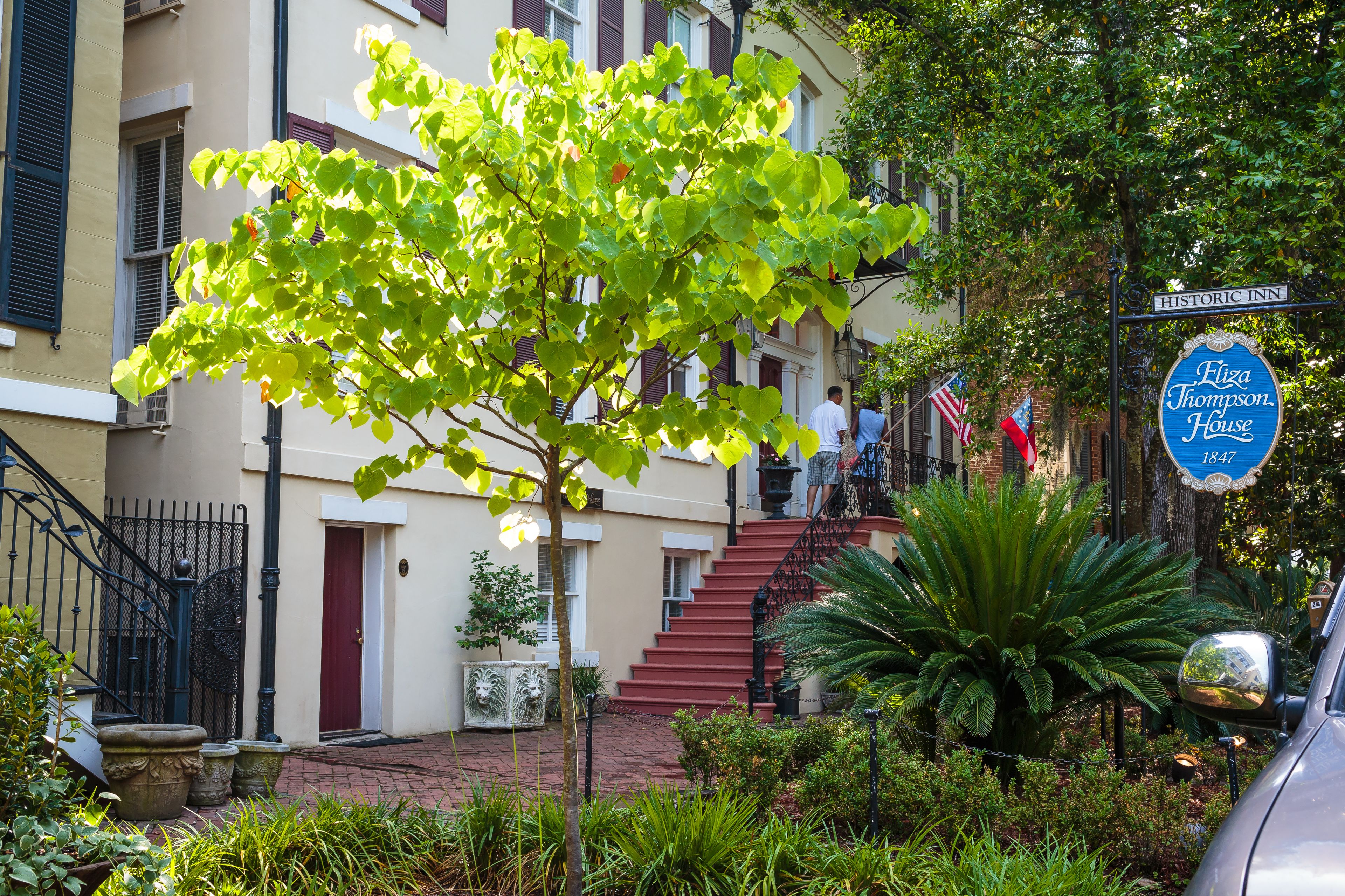 Un edificio histórico con una escalera roja, un letrero que dice Historic Inn, y un árbol en primer plano.