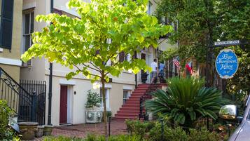 Un edificio histórico con una escalera roja, un letrero que dice Historic Inn, y un árbol en primer plano.