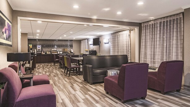 A hotel lobby with a seating area, a bar, and a kitchen in the background. - Wingate by Wyndham Brunswick GA / I-95 (Brunswick)