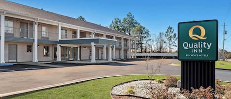 A Quality Inn by Choice Hotels building with a covered entrance and a parking lot.