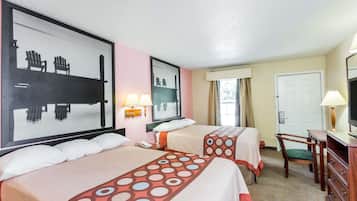 A hotel room with two beds, a desk, a chair, a TV, and a window with curtains.