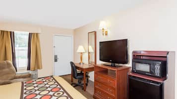 A hotel room with a bed, a desk, a television, a microwave, and a chair.