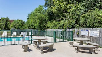 Una piscina al aire libre de temporada, sillones reclinables de piscina