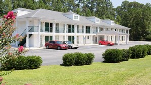 Un motel composé d’un bâtiment à deux étages, de plusieurs chambres et d’un espace de stationnement.