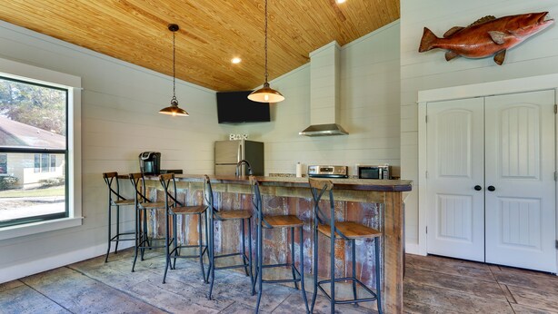 Una cocina con techo de madera, una decoración de pescado y una zona de bar con taburetes.
