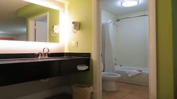 Une salle de bain avec un lavabo noir, un miroir, des toilettes et une baignoire.