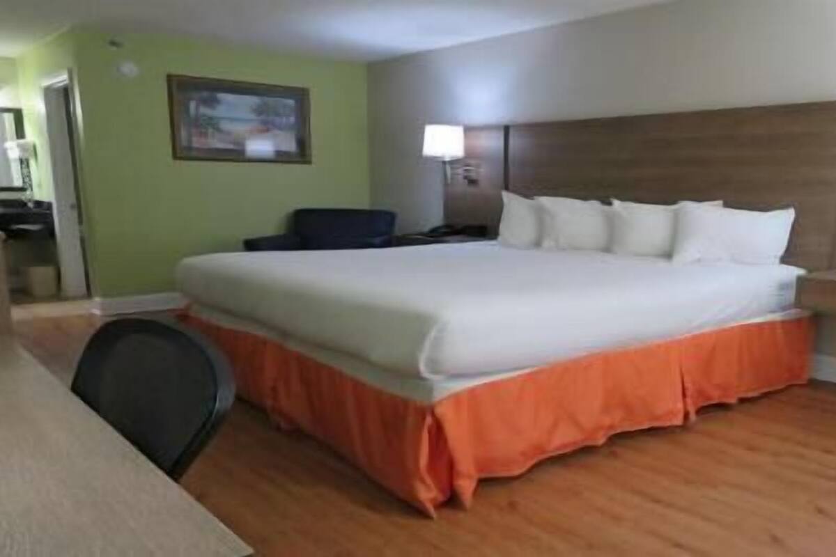 A hotel room with a bed, a desk, and a chair.