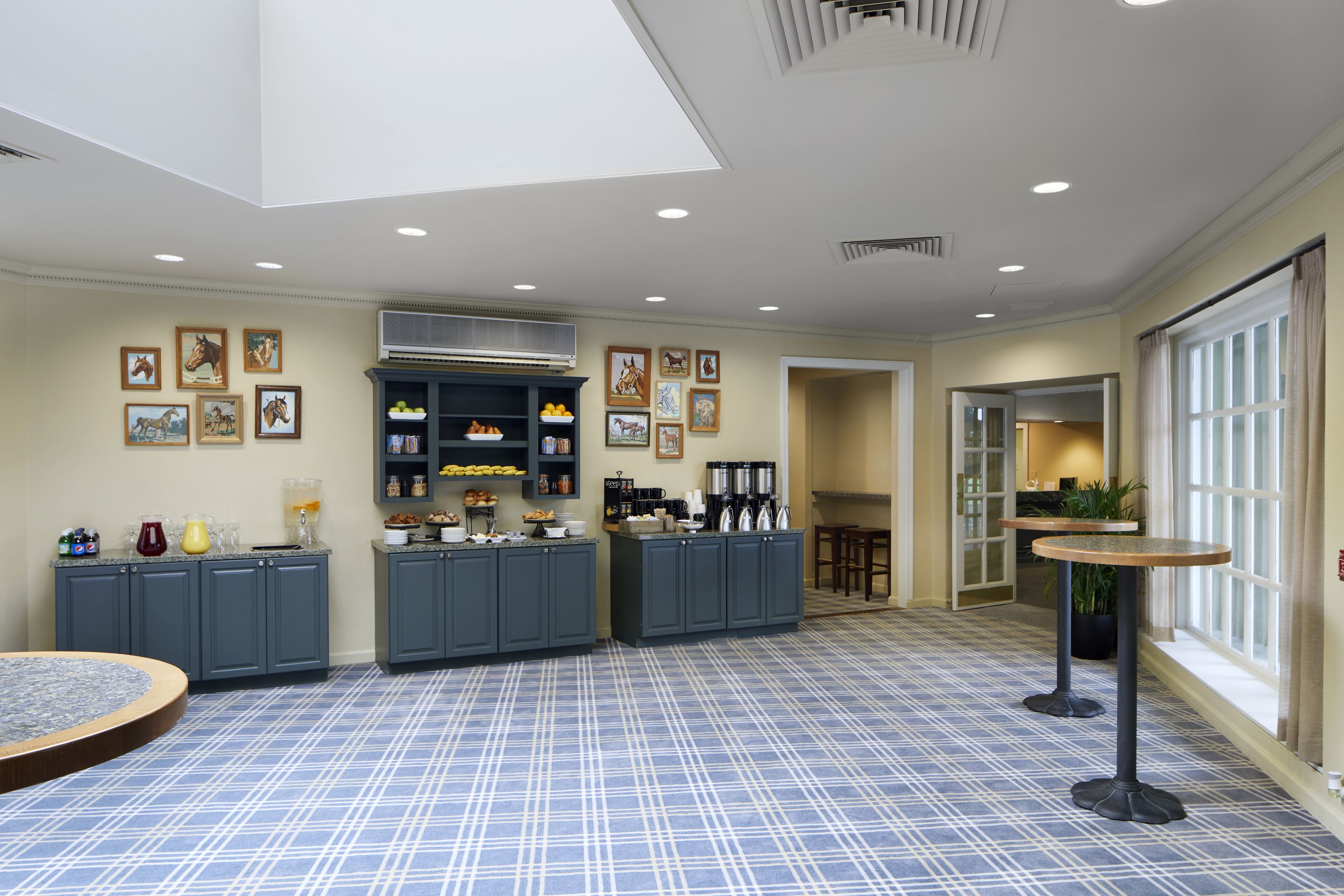 A spacious kitchen with grey cabinets, a central island, and a blue checkered floor.